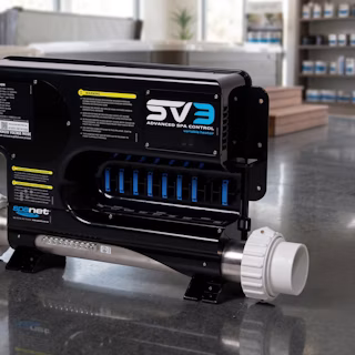 A black and silver spa heater unit labeled "SV3 Advanced Spa Control variable heater" sits on a reflective floor, featuring control labels, warning stickers, and white pipe connectors at each end.